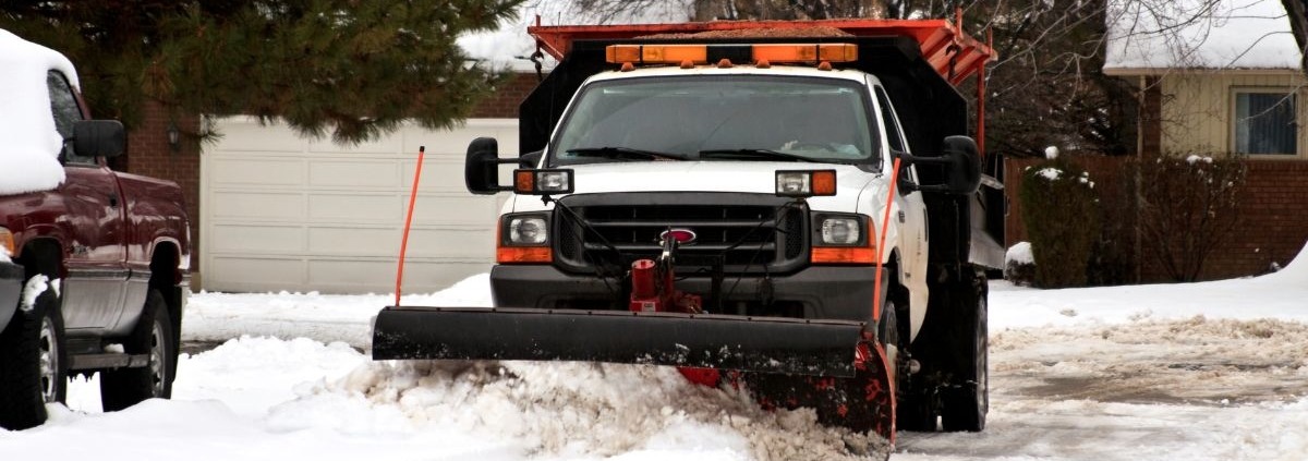 truck plowing through snow - Spade Landscaping snow plowing services