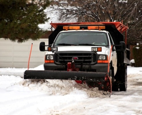 truck plowing through snow - Spade Landscaping snow plowing services
