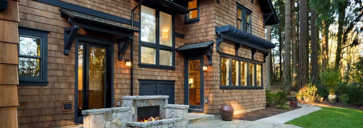 back of home with a stone outdoor fireplace - Spade Landscaping outdoor fireplace