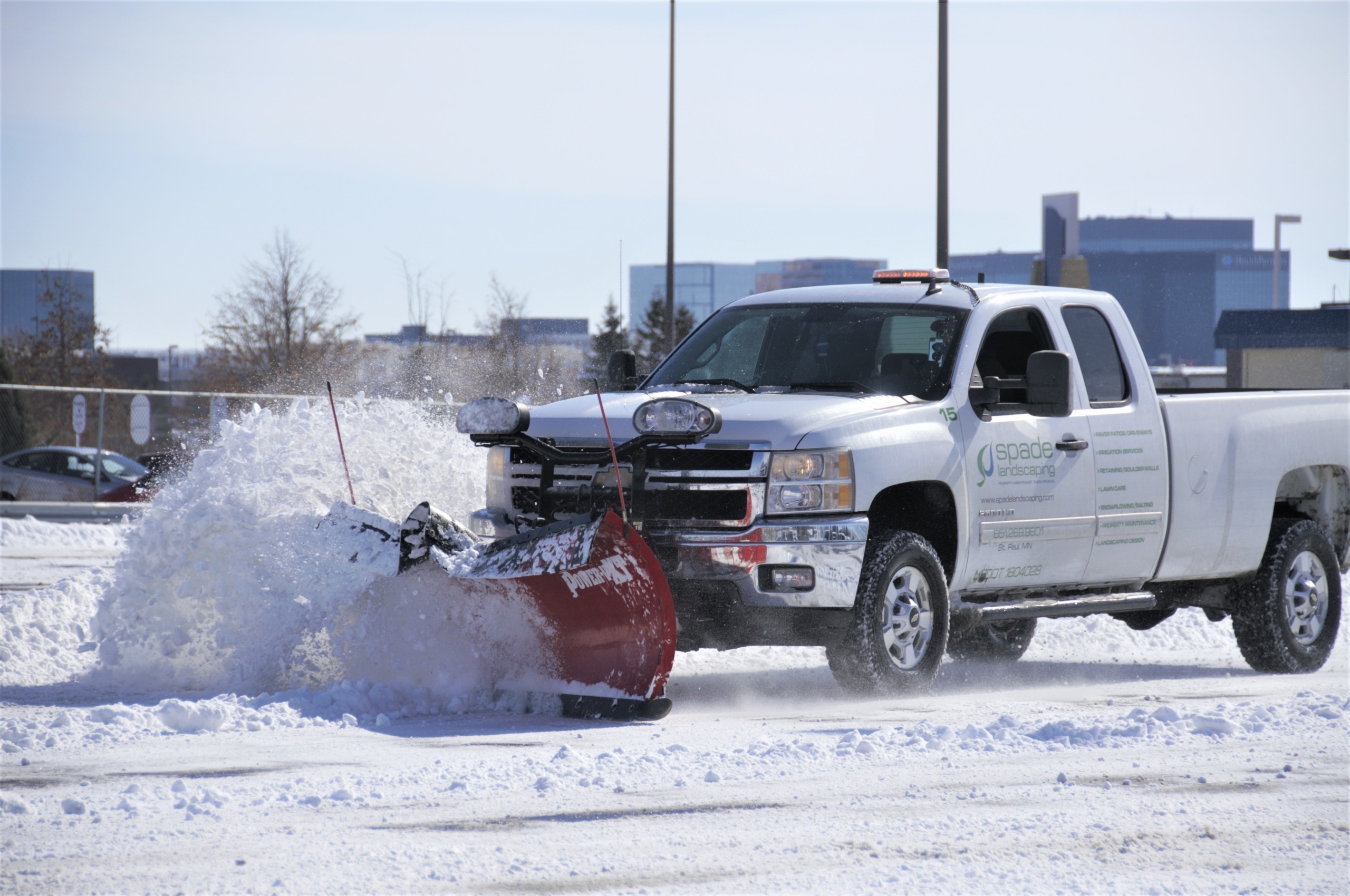 white truck plowing snow - Spade Landscaping commercial snow removal