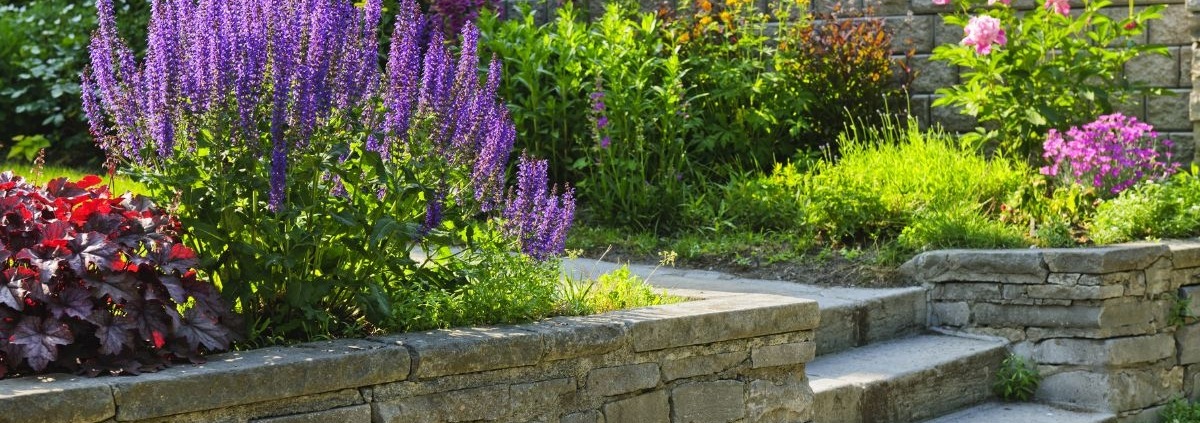 stone retaining walls with flowers and plants - Spade Landscaping commercial landscaping services