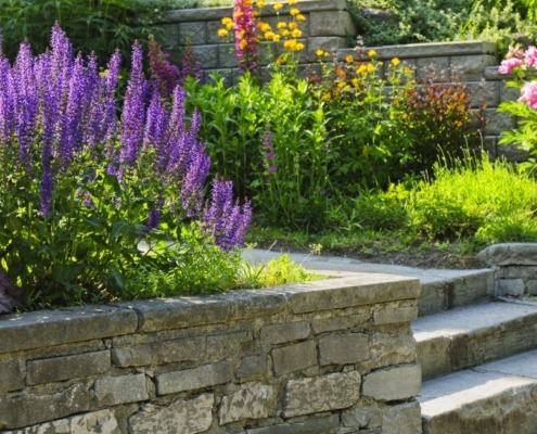 stone retaining walls with flowers and plants - Spade Landscaping commercial landscaping services