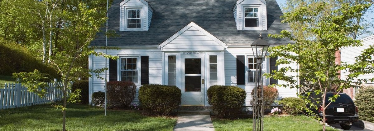 exterior of a white home with a flat front yard - Spade Landscaping lawn care services near Forest Lake, MN